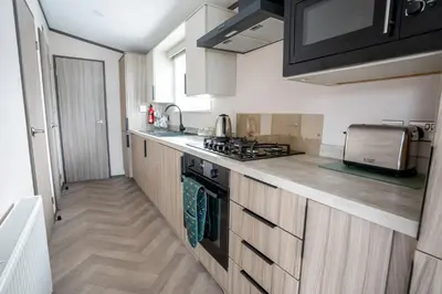 a kitchen with a sink and a stove top oven at Valley View - Newquay Bay Resort near Porth Beach in Newquay