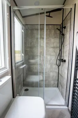 a shower with a glass door in a bathroom at Valley View - Newquay Bay Resort near Porth Beach in Newquay