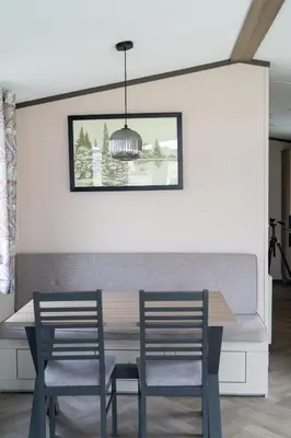 a dining room with a table and two chairs at Valley View - Newquay Bay Resort near Porth Beach in Newquay