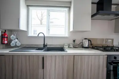 a kitchen with a sink and a window at Valley View - Newquay Bay Resort near Porth Beach in Newquay