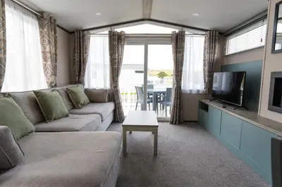 a living room with a couch and a tv at Valley View - Newquay Bay Resort near Porth Beach in Newquay