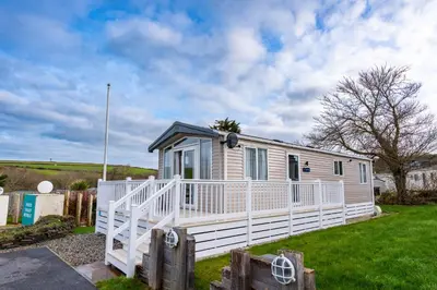 a tiny house with a white railing on a yard at Valley View - Newquay Bay Resort near Porth Beach in Newquay