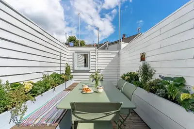 a small patio with a table and chairs at Waterside cottage - log burner - 10 mins to Falmouth in Flushing