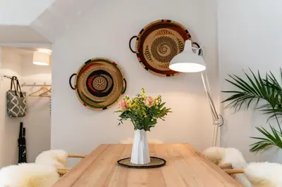 a dining room table with a vase of flowers on it at Waterside cottage - log burner - 10 mins to Falmouth in Flushing