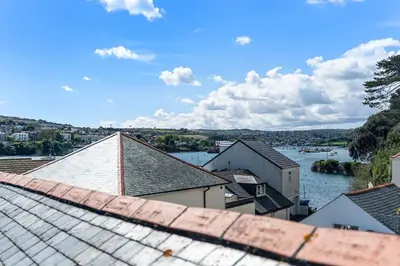 a view of a river from the roofs of houses at Waterside cottage - log burner - 10 mins to Falmouth in Flushing