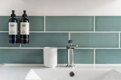 two bottles of wine sitting on a bathroom sink at Waterside cottage - log burner - 10 mins to Falmouth in Flushing