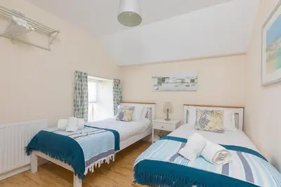 a bedroom with two beds and a window at Captain's Rest in St Ives