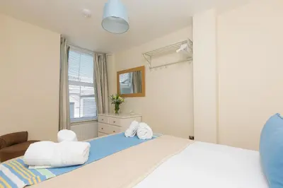 a bedroom with a large bed with towels on it at Captain's Rest in St Ives