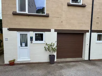 a building with a garage with a plant in front of it at The Shack 1 bedroom apartment in Newquay