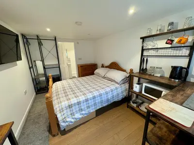 a small bedroom with a bed and a desk at The Shack 1 bedroom apartment in Newquay