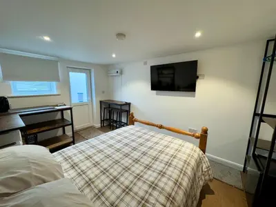a bedroom with a bed and a flat screen tv at The Shack 1 bedroom apartment in Newquay