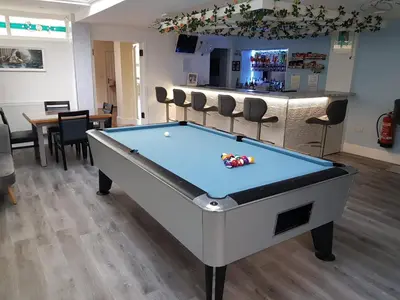 a pool table in a room with a bar at OYO Minerva Guesthouse in Newquay