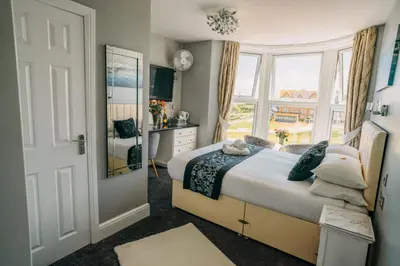 a bedroom with a bed and a large window at OYO Minerva Guesthouse in Newquay