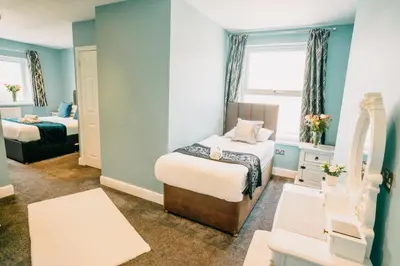 a small room with two beds and a window at OYO Minerva Guesthouse in Newquay
