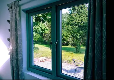 a window with a view of a yard at Bream Barn - sea view, woodburner, easy walk to the beach, parking, full kitchen in Falmouth