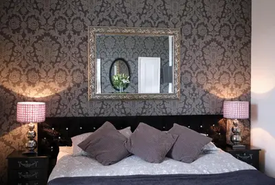a bedroom with a bed with a mirror and pillows at Beacon Crag in Porthleven