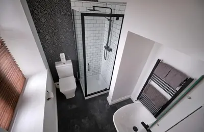 a small bathroom with a toilet and a shower at Beacon Crag in Porthleven