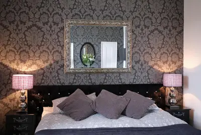 a bedroom with a bed with a mirror and pillows at Beacon Crag in Porthleven