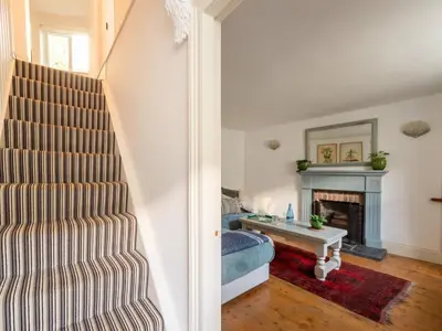 a living room with a staircase and a fireplace at Holiday Home Hillside by Interhome in Portloe