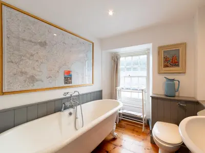 a bathroom with a tub and a map on the wall at Holiday Home Hillside by Interhome in Portloe