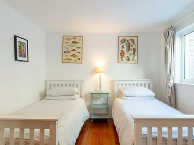 two beds in a room with white walls at Holiday Home Hillside by Interhome in Portloe