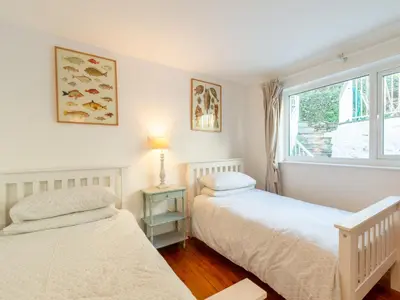 two beds in a room with a window at Holiday Home Hillside by Interhome in Portloe