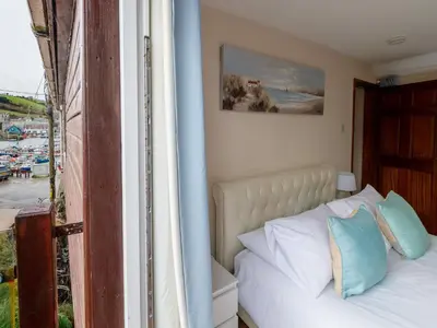 a bedroom with a bed and a view of a harbor at Apartment Harbourside Hideaway by Interhome in Mevagissey