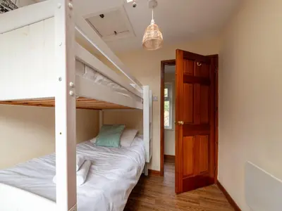 a bedroom with two bunk beds and a door at Apartment Harbourside Hideaway by Interhome in Mevagissey