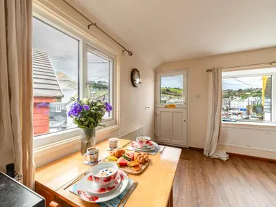 a room with a table with plates of food on it at Apartment Harbourside Hideaway by Interhome in Mevagissey
