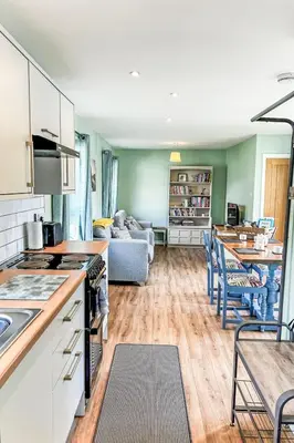 a kitchen and living room with a couch at Chalet Kingfishers Lodge by Interhome in Liskeard