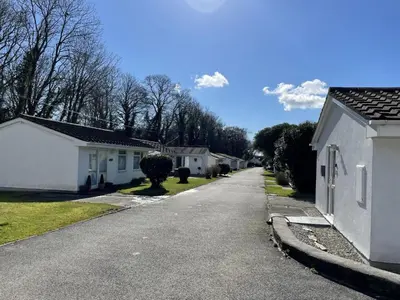 an empty street in a neighborhood with white houses at Chalet Kingfishers Lodge by Interhome in Liskeard
