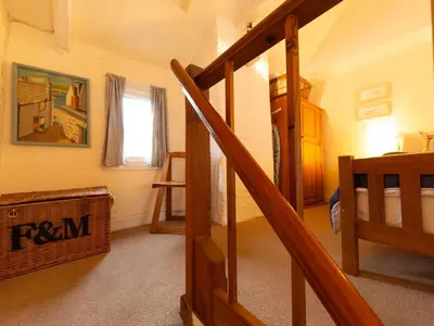 a room with a stairway and a room with a bedroom at Holiday Home Piskey Cottage by Interhome in Mevagissey