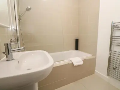 a white bathroom with a sink and a bath tub at Una, Lodge 70 in St Ives