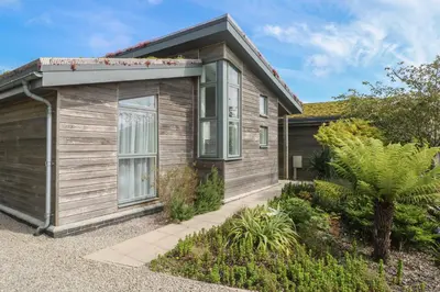 a small wooden house with a garage at Una, Lodge 70 in St Ives