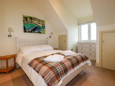 a bedroom with a bed and a painting on the wall at Blue Horizon in Port Isaac