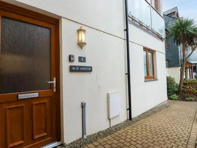 a door to a building with a sign on it at Blue Horizon in Port Isaac