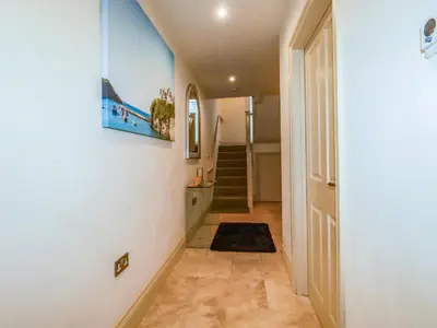 a hallway with a door and a stairway at Blue Horizon in Port Isaac