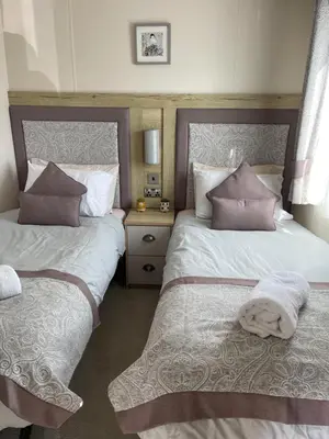 a bedroom with two beds with pillows at Summer Days at Seven Bays Padstow in Padstow