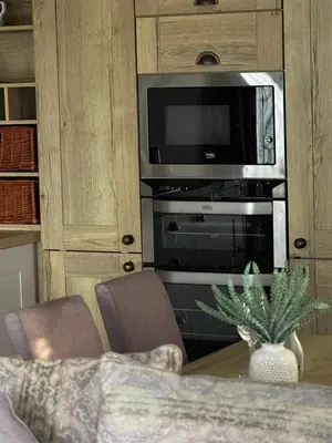 a living room with a television and a table with chairs at Summer Days at Seven Bays Padstow in Padstow