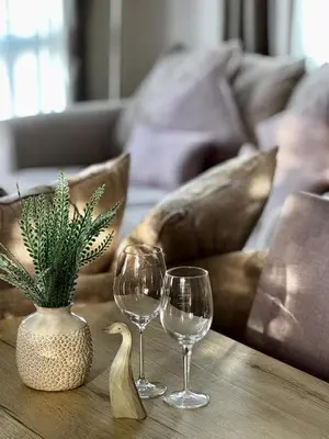 a table with three wine glasses and a plant on it at Summer Days at Seven Bays Padstow in Padstow