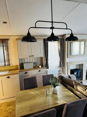 a living room with a table and a kitchen at Summer Days at Seven Bays Padstow in Padstow