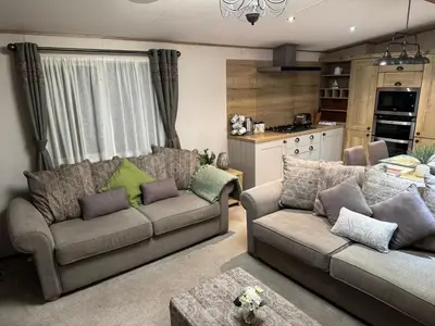 a living room with two couches and a kitchen at Summer Days at Seven Bays Padstow in Padstow