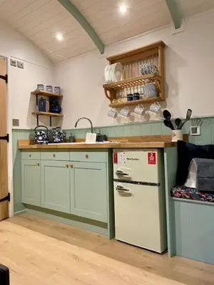 a kitchen with green cabinets and a white refrigerator at Waters Meet in Warleggan