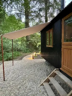 awning on the side of a cabin in the woods at Waters Meet in Warleggan