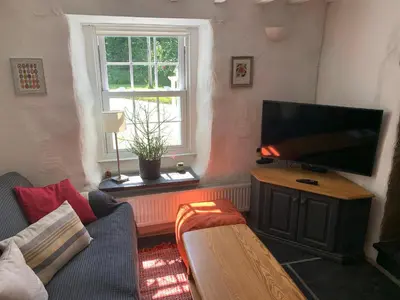 a living room with a couch and a flat screen tv at Kernyk in Redruth