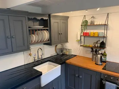 a kitchen with blue cabinets and a sink at Kernyk in Redruth