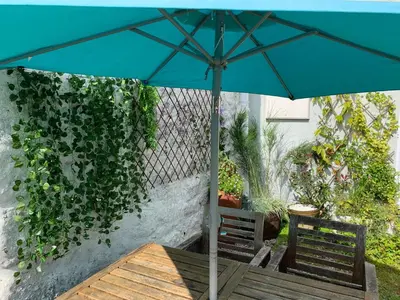 a blue umbrella over a wooden table and chairs at Kernyk in Redruth