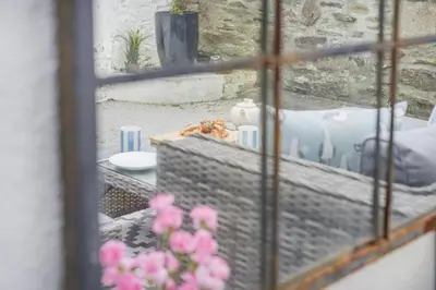 a view from a window of a table with pink flowers at 2 Bed in Fowey oc-r30265 in Fowey
