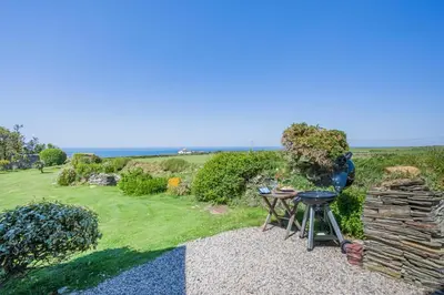 a backyard with a grill and a pile of logs at 4 Bed in Trevillick oc-m30376 in Tintagel