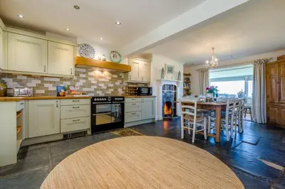 a kitchen with a table and a stove top oven at 4 Bed in Trevillick oc-m30376 in Tintagel